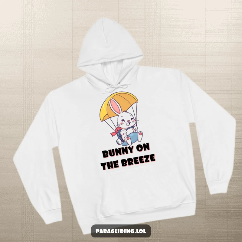 Funny hoodie with a determined, smiling bunny steering a paraglider with a grin, designed for comfort and expressing a love for adventure.