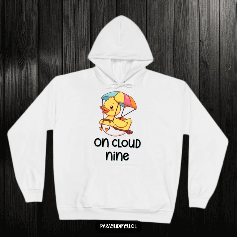 Funny hoodie with a cheerful duck enjoying the scenic view from its colorful paraglider, cozy and adventurous.