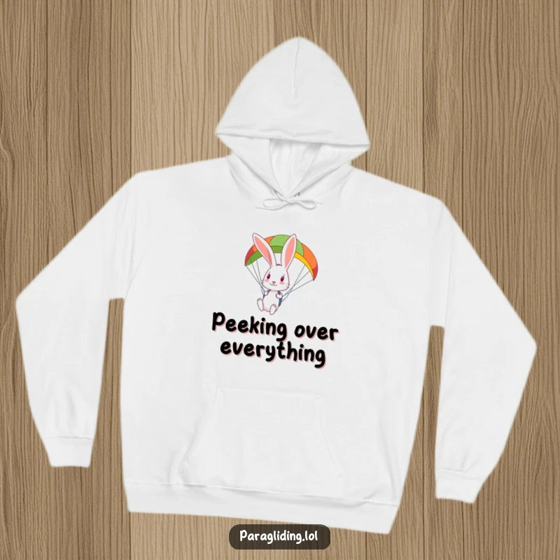 Funny curious rabbit looks down from a colorful paraglider, a cozy hoodie for those who love to observe from on high.