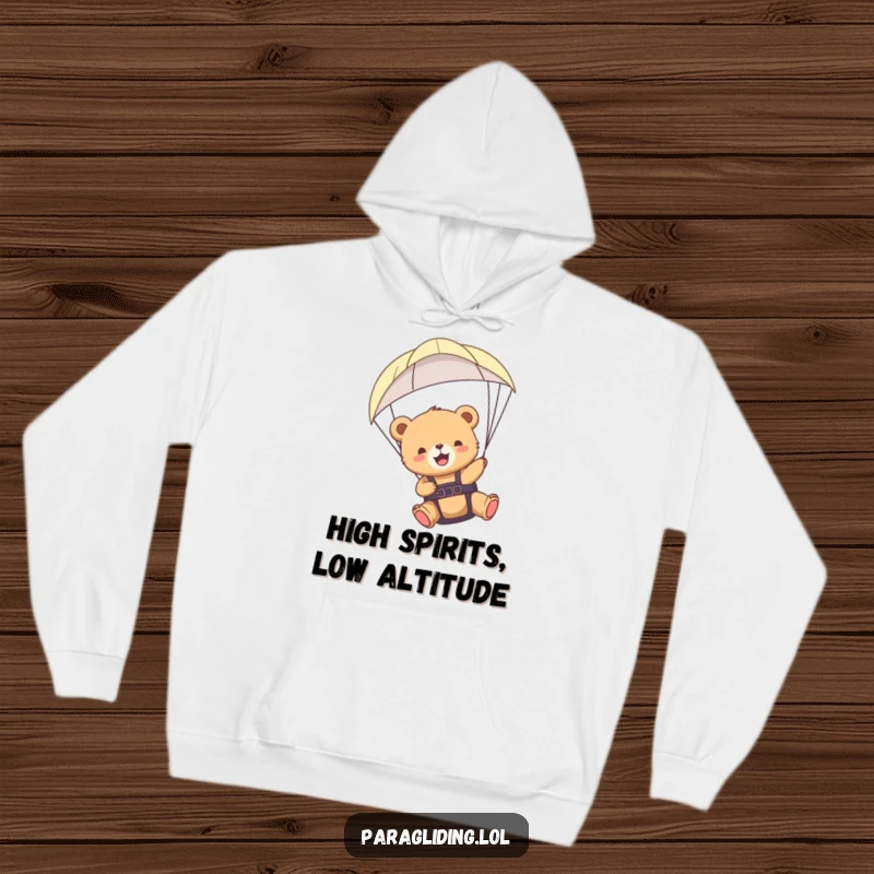 Funny bear cub paragliding hoodie showing a cub happily gliding through the air, a whimsical and cozy design.