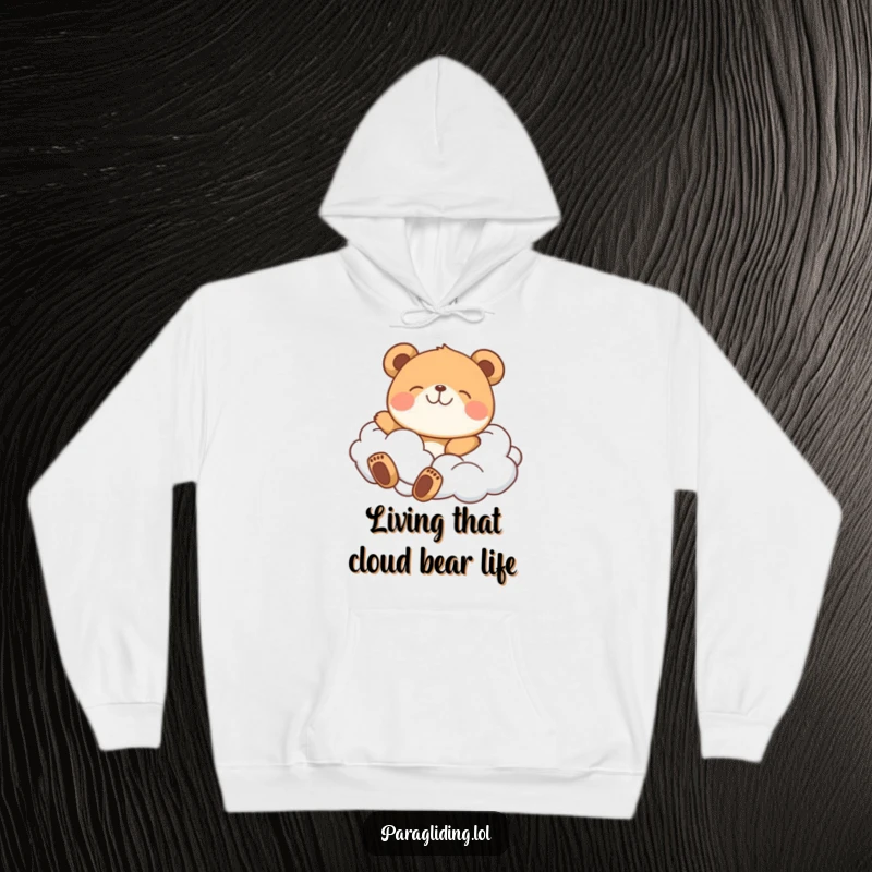 Funny hoodie showing a contented bear drifting peacefully amidst soft, airy clouds, radiating happiness.