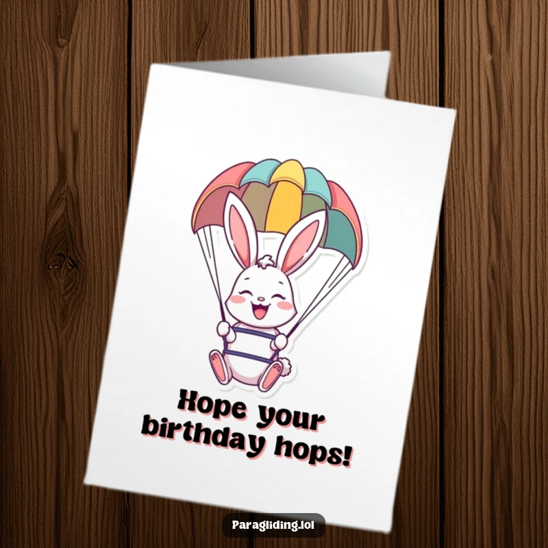 Funny Free Printable Birthday Card showing a happy bunny smiling broadly while floating peacefully under a colorful paraglider canopy.