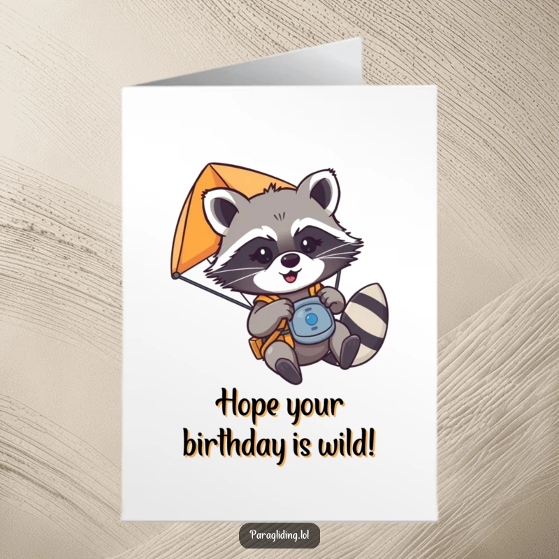 Funny Free Printable Birthday Card: A mischievous raccoon playfully tugging paraglider controls, adding chaos to birthday wishes.