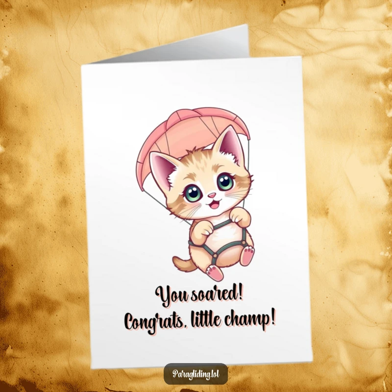 Funny free printable congratulations card showing a happy kitten bravely paragliding, celebrating achievements with a thrill. A unique downloadable.