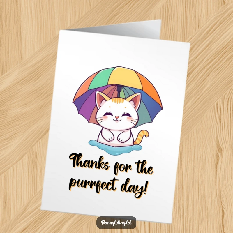 Free Printable Thank You Card: A smiling cat is pictured floating peacefully under a vivid rainbow umbrella, conveying thanks.
