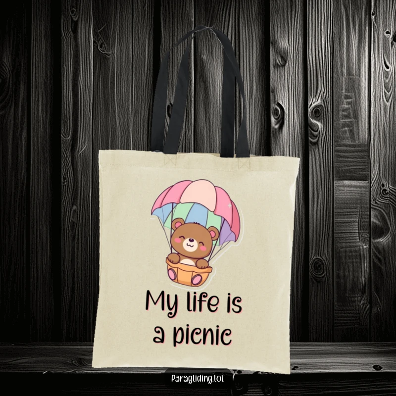 Funny tote bag with a happy bear floating peacefully in a colorful parachute, perfect for carrying essentials with a serene touch, great funny gift.