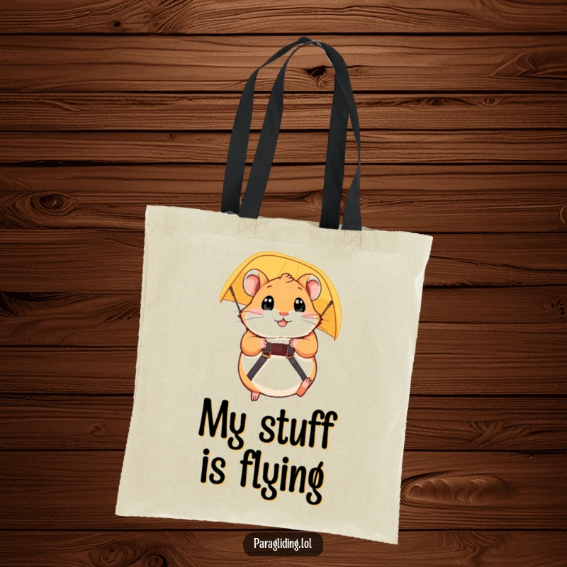 Funny tote bag showcasing a plump hamster gripping a paraglider strap, eyes wide with anticipation for a hilarious adventure. Gift.